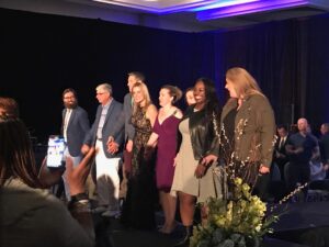 The event organizer and founder of Get Your Rear in Gear Philadelphia takes a bow with colorectal cancer survivors and thrivers at the Get Your Rear In Gear 10th Annual Runway for a Cause
