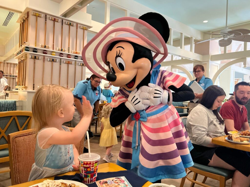 toddler waves to Minnie Mouse