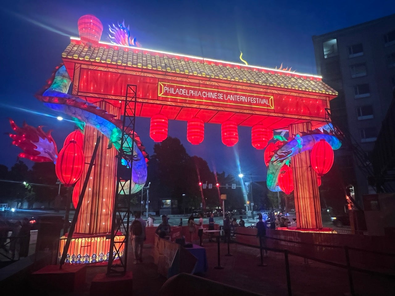 Festival Entrance to the 2024 Philadelphia Chinese Lantern Festival. A giant rectangular archway lit up in red against a night sky.